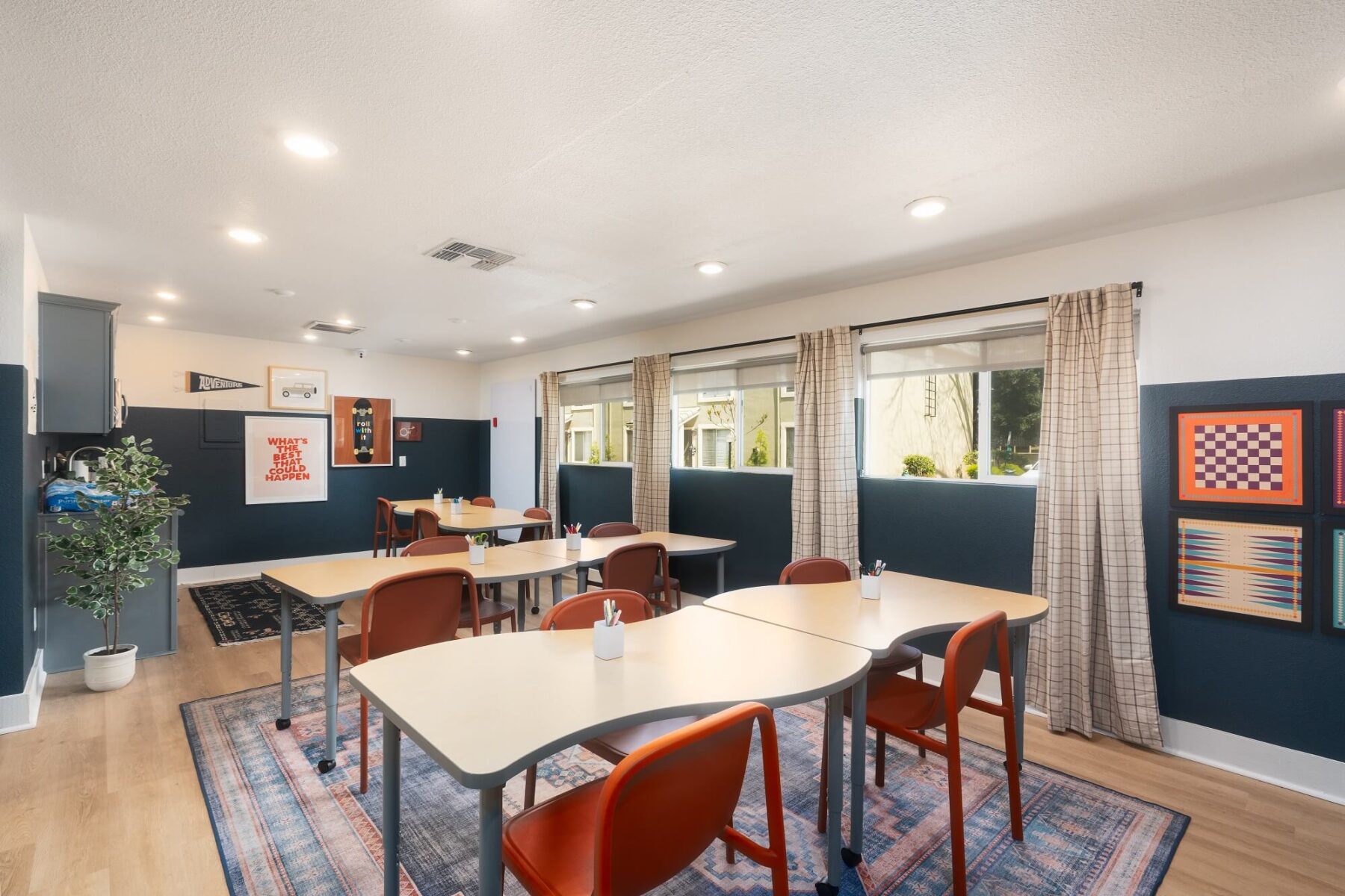 Kids clubhouse with designer lighting, windows, table seating, wood-style flooring, and wall décor
