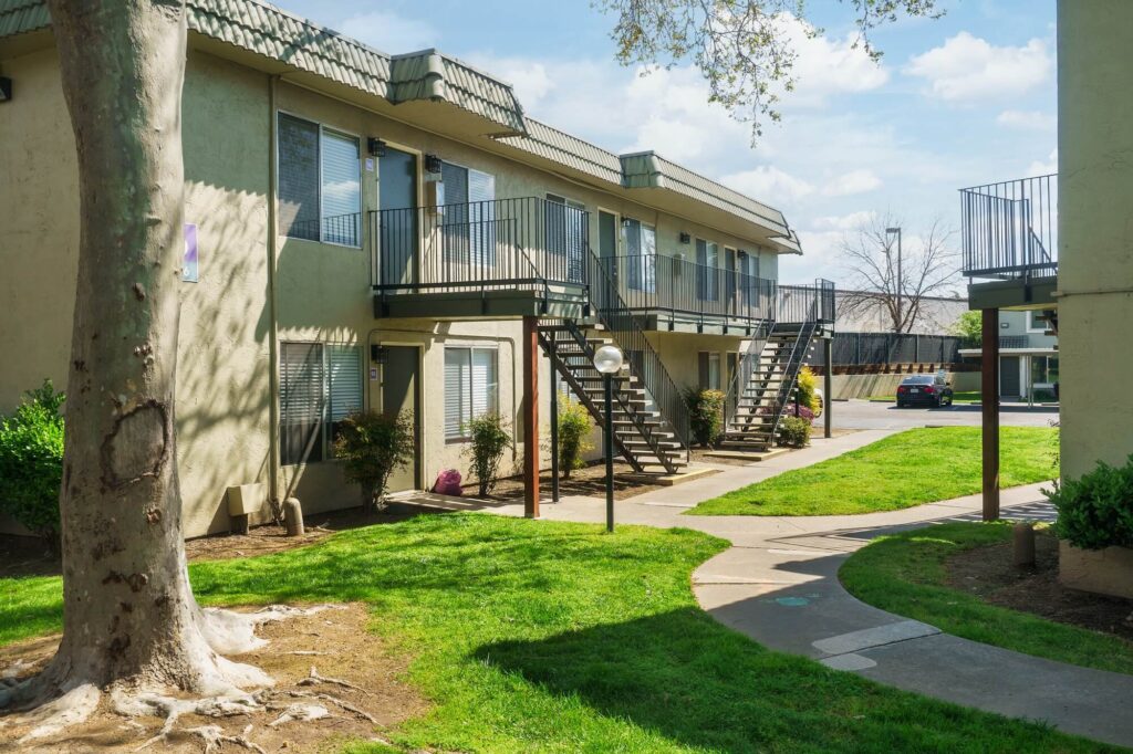 Exterior view of apartment complex with green landscaping