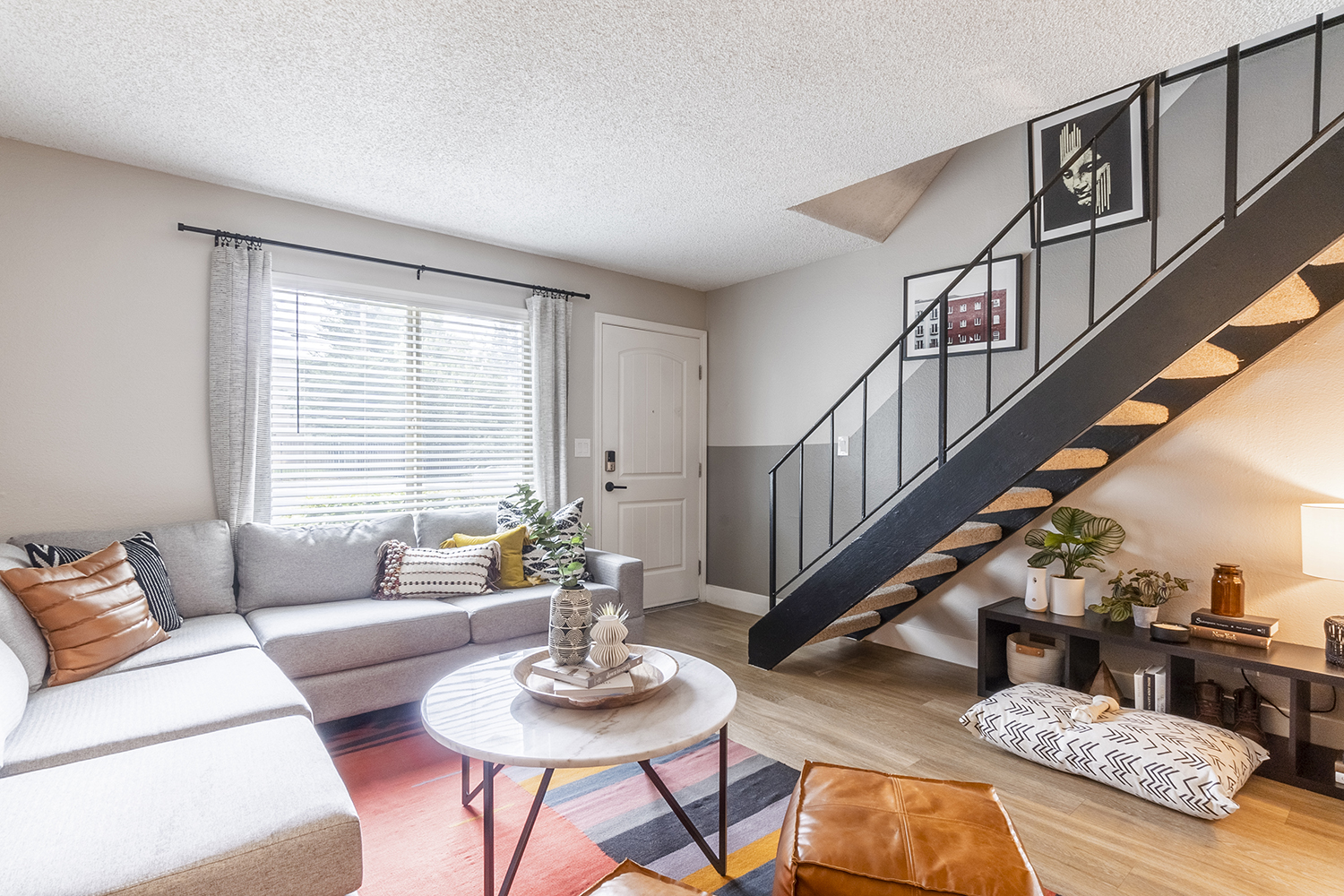 Living room with couch seating, wood-style flooring, natural lighting, and doggy bed